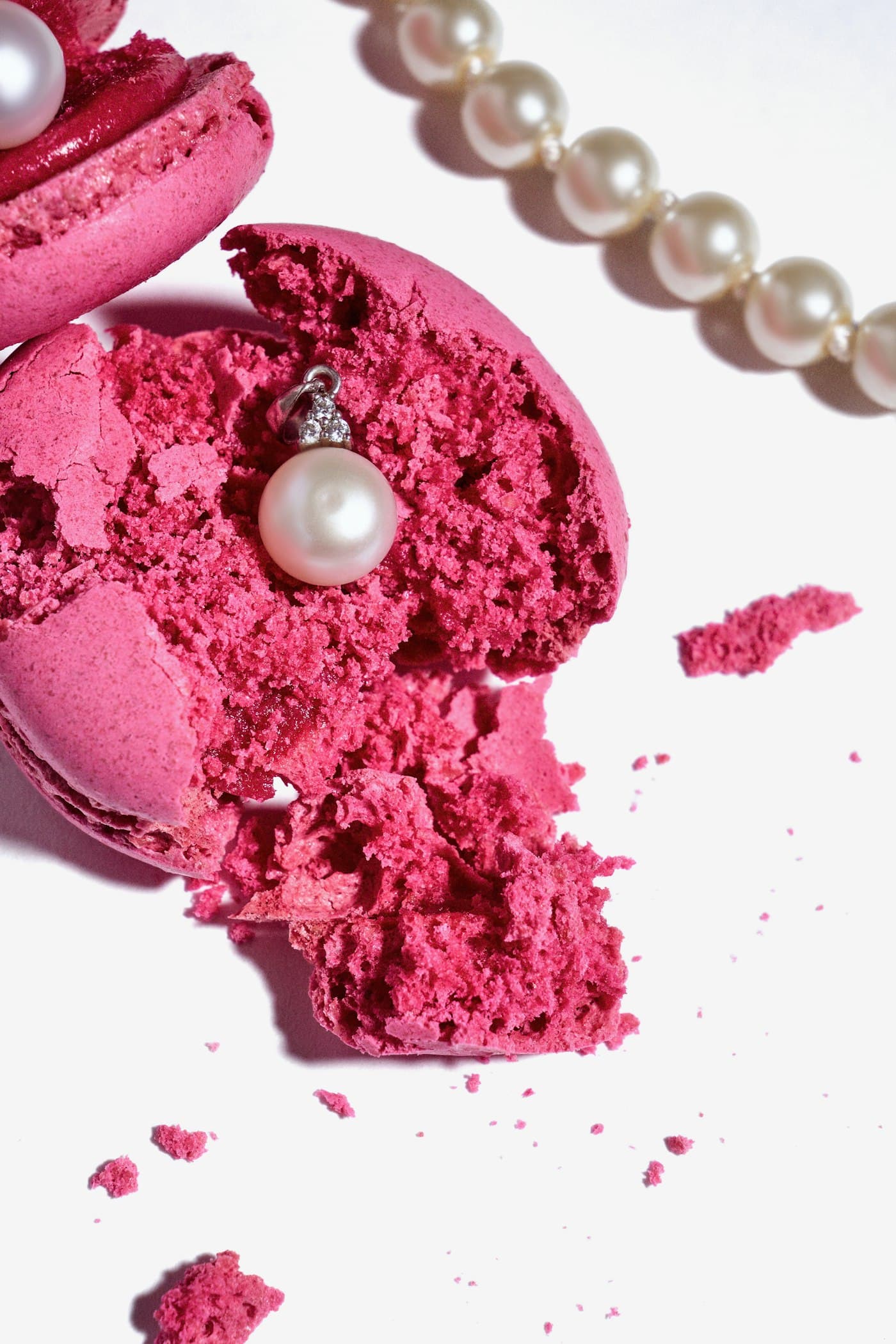 Makaron merah muda terbelah dengan untaian mutiara