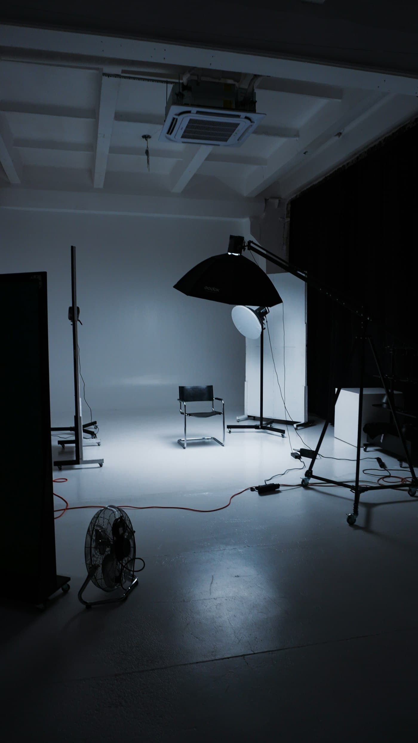 Studio kosong dengan lampu, payung reflektor, dan kursi